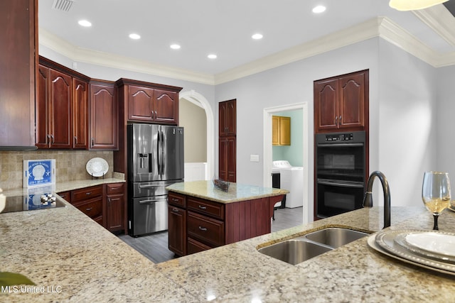 kitchen with visible vents, black appliances, a sink, light stone countertops, and dark brown cabinets