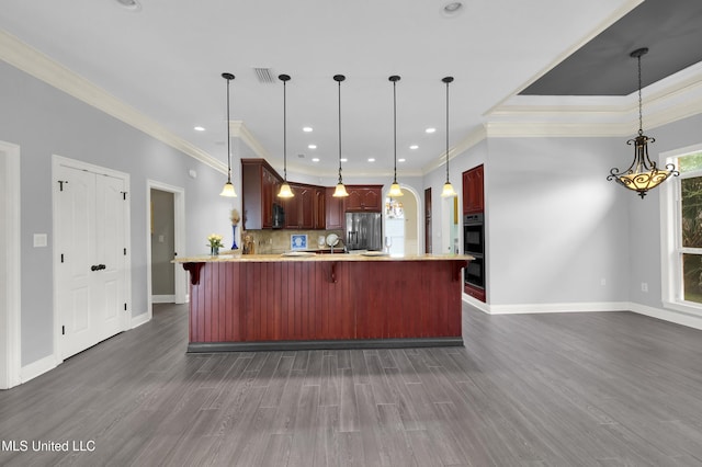 kitchen featuring dark wood finished floors, a peninsula, a breakfast bar, stainless steel refrigerator with ice dispenser, and tasteful backsplash