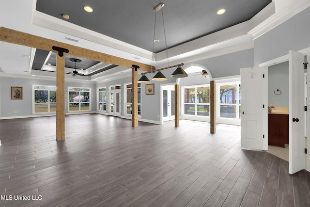 interior space with dark wood finished floors, a tray ceiling, crown molding, and a ceiling fan