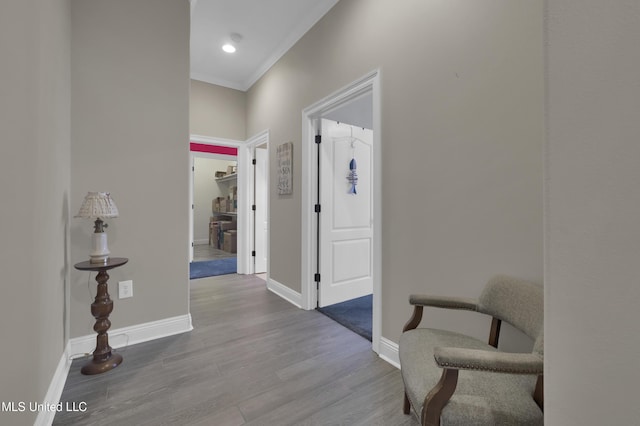 hallway with baseboards, wood finished floors, and ornamental molding