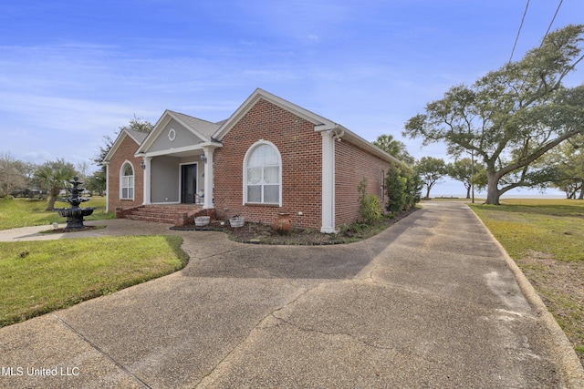 view of front facade with brick siding and a front lawn