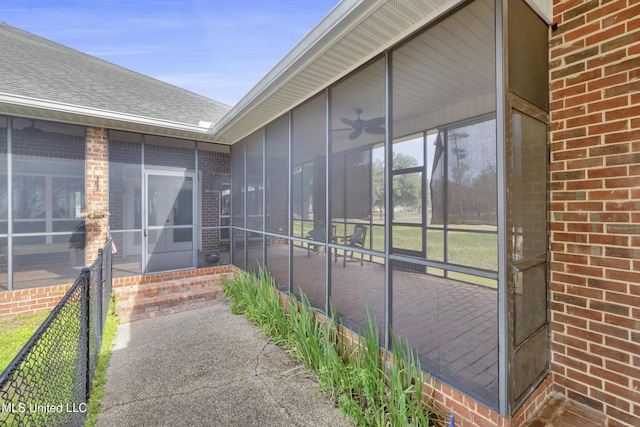 view of patio / terrace featuring fence and a sunroom