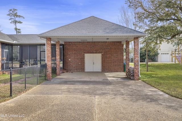 exterior space featuring an attached carport, driveway, and fence