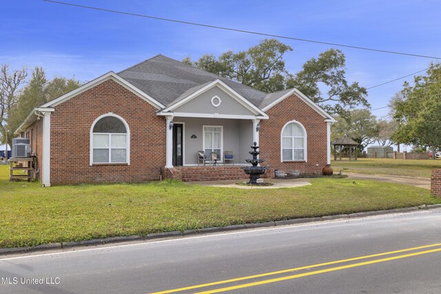 view of front facade with a gazebo, a front lawn, brick siding, and roof with shingles