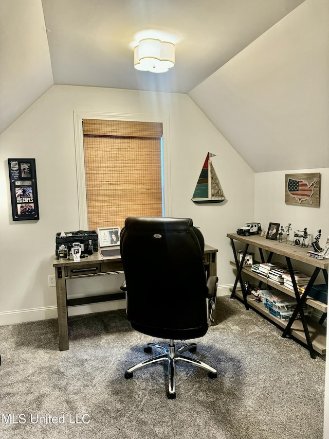 carpeted home office with vaulted ceiling