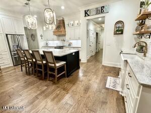 kitchen featuring white cabinets, dark hardwood / wood-style flooring, a kitchen island, and decorative light fixtures