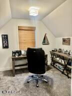 carpeted home office featuring lofted ceiling