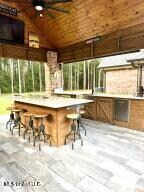 view of patio featuring ceiling fan and exterior bar