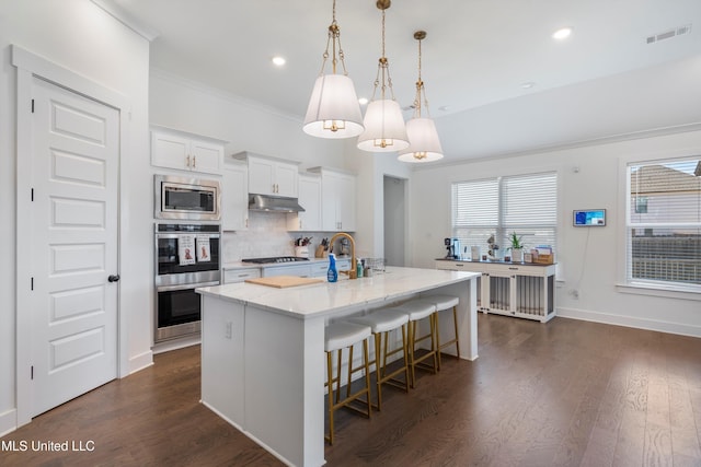 kitchen featuring dark wood finished floors, visible vents, appliances with stainless steel finishes, and decorative backsplash