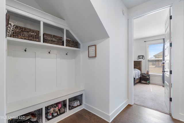 mudroom with vaulted ceiling, baseboards, and wood finished floors