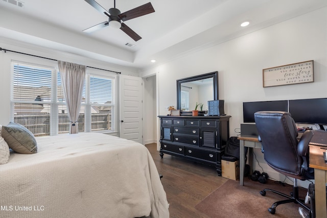 bedroom featuring a tray ceiling, visible vents, dark wood-type flooring, and recessed lighting