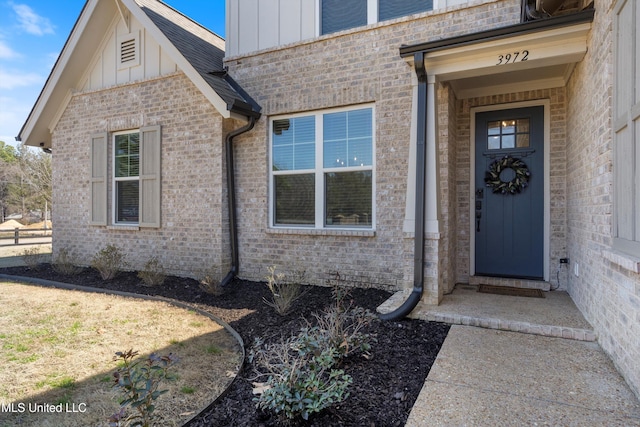 property entrance with brick siding and board and batten siding