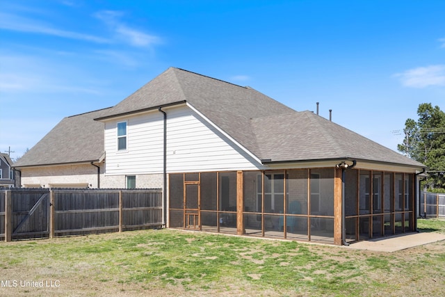 back of house with a gate, a sunroom, fence, a yard, and a shingled roof