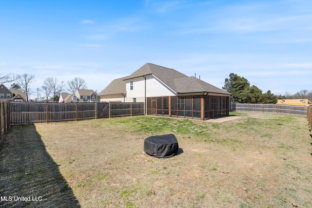 view of yard with a fenced backyard and a sunroom