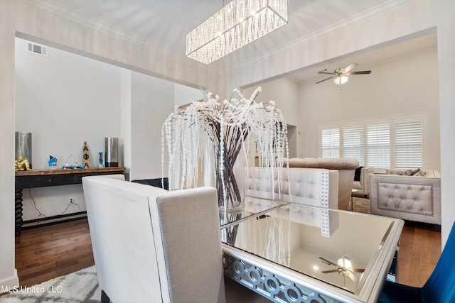 dining room with ornamental molding, hardwood / wood-style flooring, and ceiling fan with notable chandelier