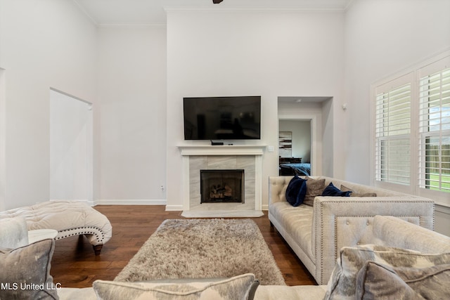 living room with crown molding, dark hardwood / wood-style floors, and a tile fireplace