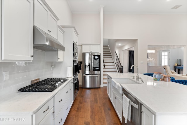 kitchen with a kitchen island with sink, dark hardwood / wood-style floors, white cabinets, and stainless steel appliances