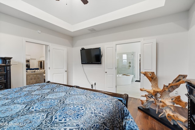 bedroom with ceiling fan, ensuite bathroom, and hardwood / wood-style floors