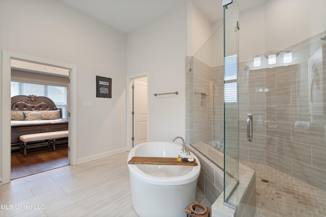 bathroom with shower with separate bathtub and hardwood / wood-style flooring