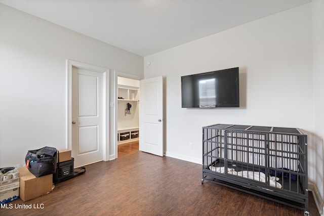 bedroom with dark hardwood / wood-style flooring and a crib