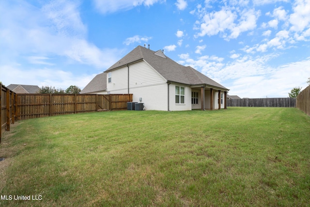 rear view of property with a yard and cooling unit