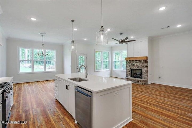 kitchen with white cabinetry, a wealth of natural light, appliances with stainless steel finishes, and a center island with sink