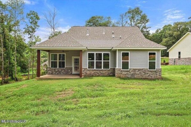 back of house featuring a lawn and a patio