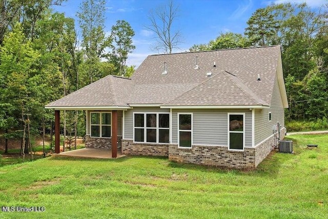 back of property featuring central air condition unit, a lawn, and a patio