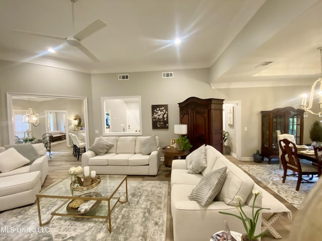 living room featuring a chandelier, ceiling fan, baseboards, wood finished floors, and ornamental molding