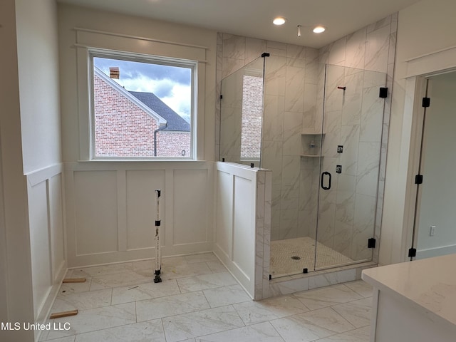 1805 Bakersfield Way, Nesbit, MS 38651 - bathroom with a decorative wall, marble look tiles, recessed lighting, a shower stall, and vanity
