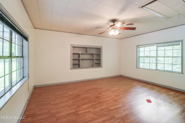 3008 Papania Ln, Gulfport, MS 39501 - unfurnished room featuring healthy amount of natural light, wood finished floors, ceiling fan, and built in features