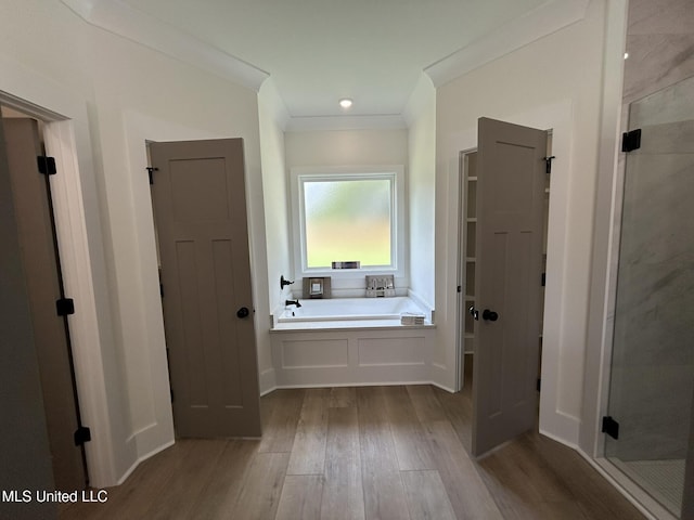 3076 Highland Ave, Diberville, MS 39540 - full bath featuring wood finished floors, a stall shower, a garden tub, crown molding, and a closet