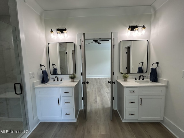 3076 Highland Ave, Diberville, MS 39540 - bathroom with wood finished floors, two vanities, ceiling fan, and a shower stall