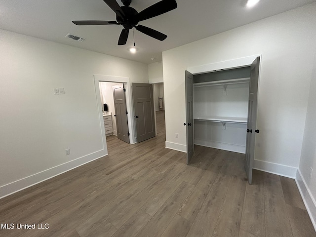 3076 Highland Ave, Diberville, MS 39540 - unfurnished bedroom with dark wood finished floors, baseboards, a closet, and connected bathroom