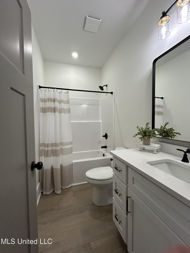 3076 Highland Ave, Diberville, MS 39540 - bathroom featuring vanity, wood finished floors, toilet, and shower / bath combo with shower curtain