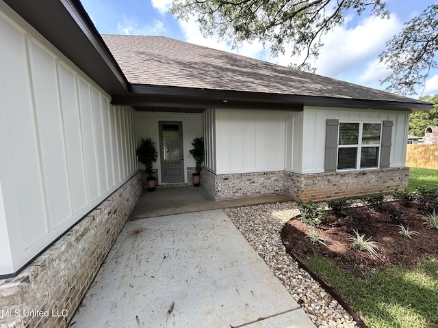 3076 Highland Ave, Diberville, MS 39540 - property entrance featuring brick siding, roof with shingles, and board and batten siding
