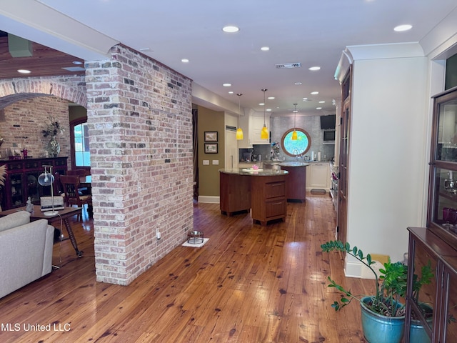 236 Sawbridge Dr, Ridgeland, MS 39157 - kitchen featuring arched walkways, a kitchen island, hardwood / wood-style flooring, open floor plan, and recessed lighting