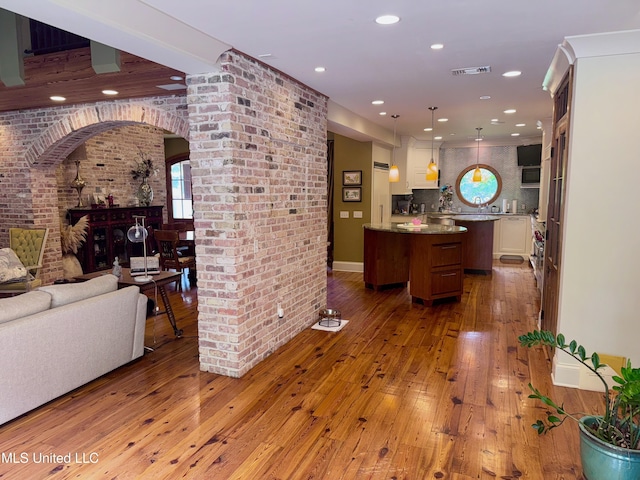 236 Sawbridge Dr, Ridgeland, MS 39157 - living area featuring arched walkways, hardwood / wood-style flooring, recessed lighting, and brick wall