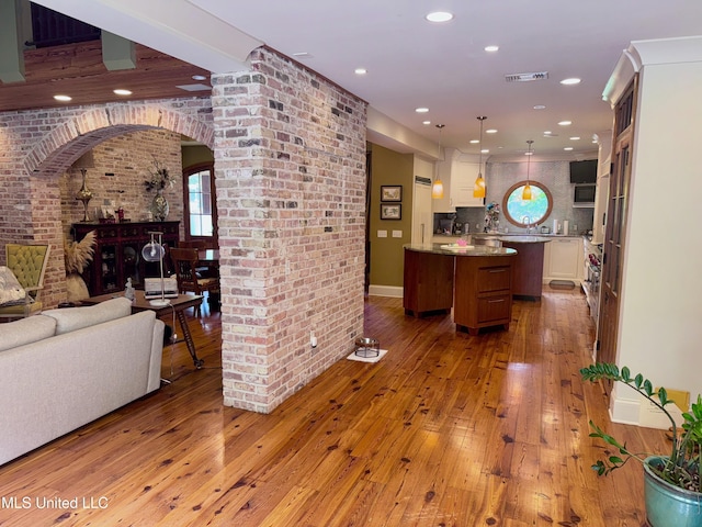 236 Sawbridge Dr, Ridgeland, MS 39157 - kitchen with arched walkways, open floor plan, hardwood / wood-style flooring, a kitchen island, and recessed lighting
