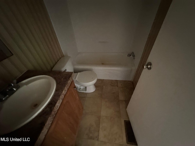 bathroom with vanity, toilet, tile patterned floors, and a washtub