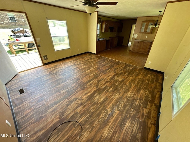 unfurnished living room with a textured ceiling, ceiling fan, and dark hardwood / wood-style flooring