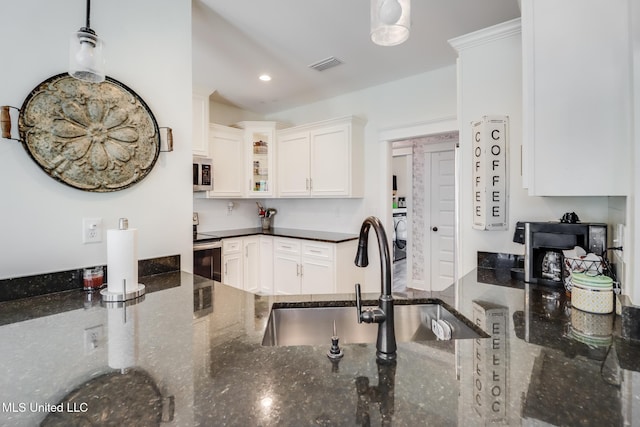 kitchen with visible vents, appliances with stainless steel finishes, dark stone counters, and glass insert cabinets