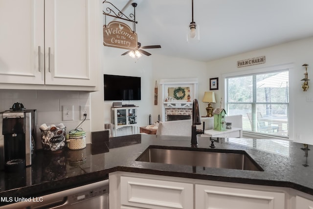 kitchen with a sink, white cabinetry, dark stone counters, dishwasher, and ceiling fan