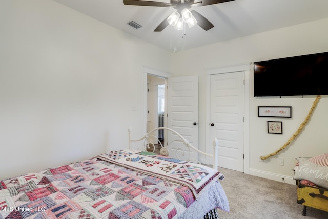 carpeted bedroom featuring a closet, visible vents, baseboards, and a ceiling fan