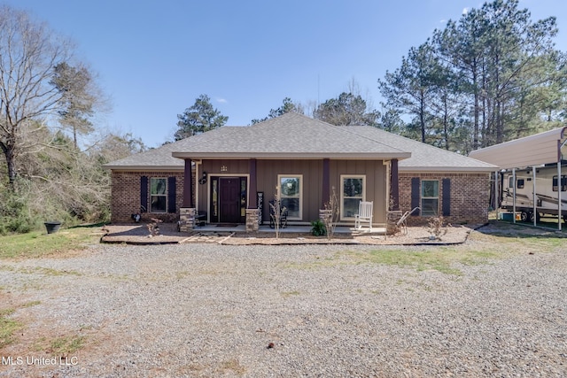 back of property with brick siding and roof with shingles