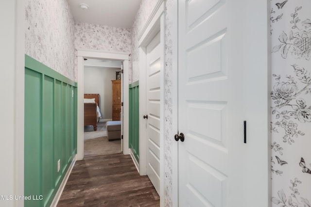 corridor featuring dark wood finished floors and wallpapered walls