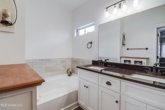 bathroom with a sink, a bath, and double vanity