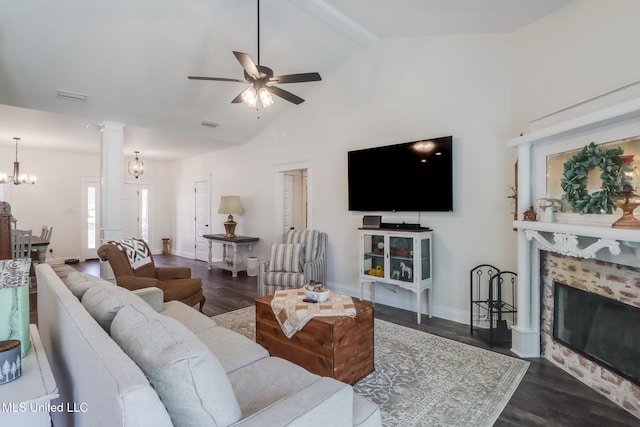 living room with a tiled fireplace, ceiling fan with notable chandelier, wood finished floors, and visible vents