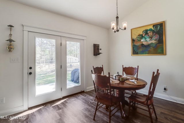 dining space with a notable chandelier, baseboards, dark wood-type flooring, and lofted ceiling