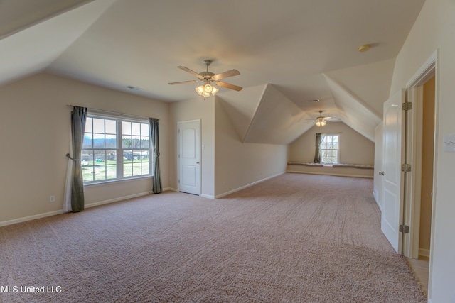 additional living space with light carpet, lofted ceiling, and a healthy amount of sunlight